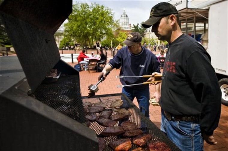 In this May 4, 2011 photo, Travis Martin, center, and Dennis Fennewald of the Boone County Cattlemans Association grill up steaks for lunch as part of the Mizzou Collegiate Cattlewoman's "Meet Your Meat" event on the University of Missouri campus in Columbia, Mo. 